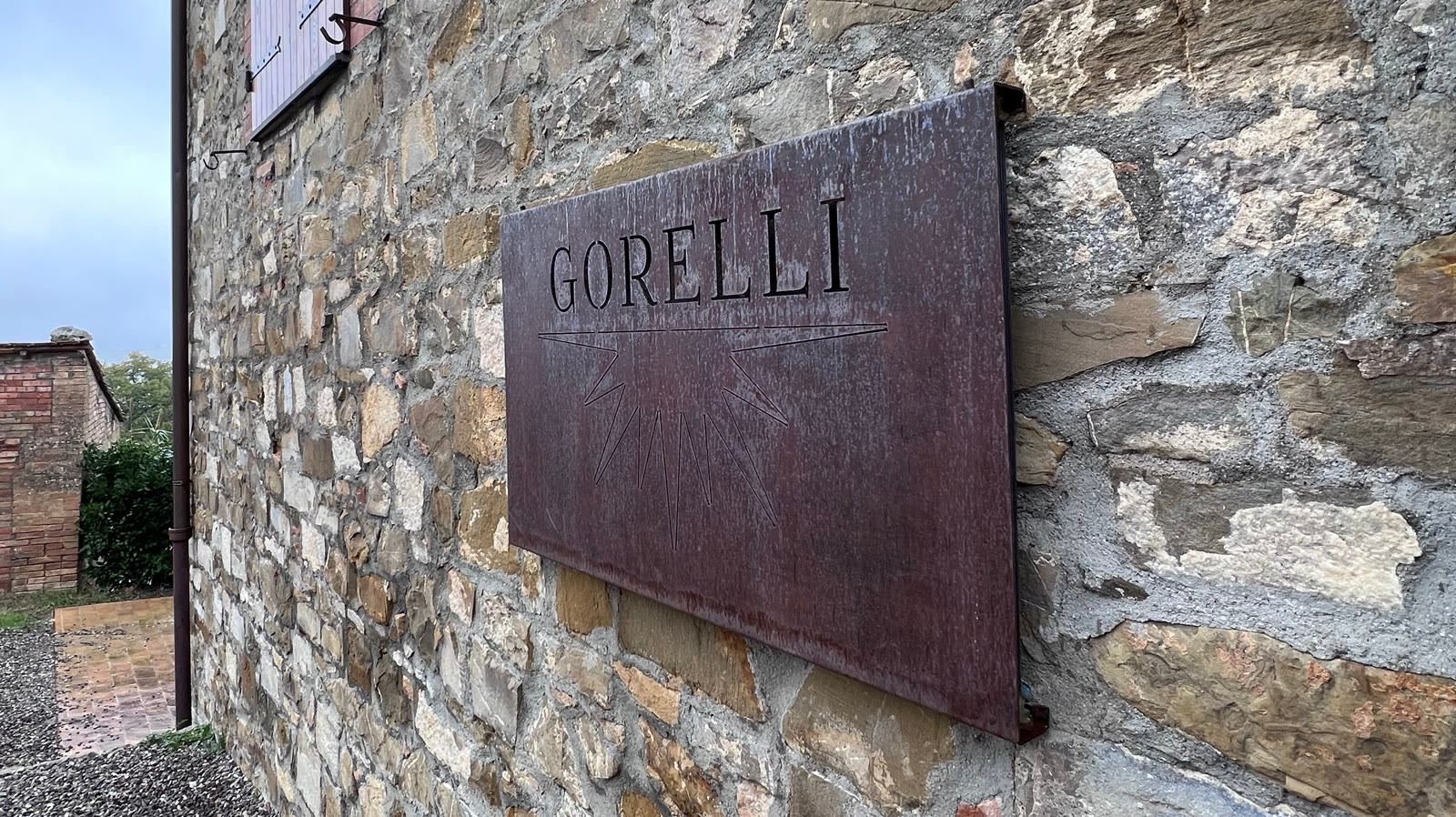 L'insegna GORELLI in acciaio su un muro di pietra
